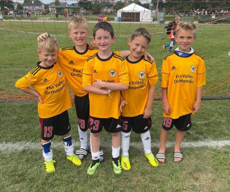 Boys playing soccer in yellow fox valley strikers jerseys