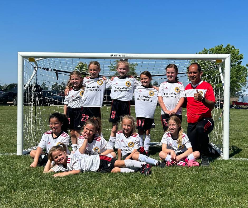 Girls playing soccer in white fox valley strikers jerseys